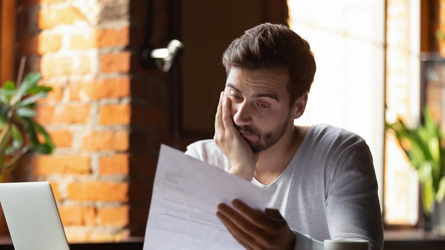 Man reading a document with a worried expression