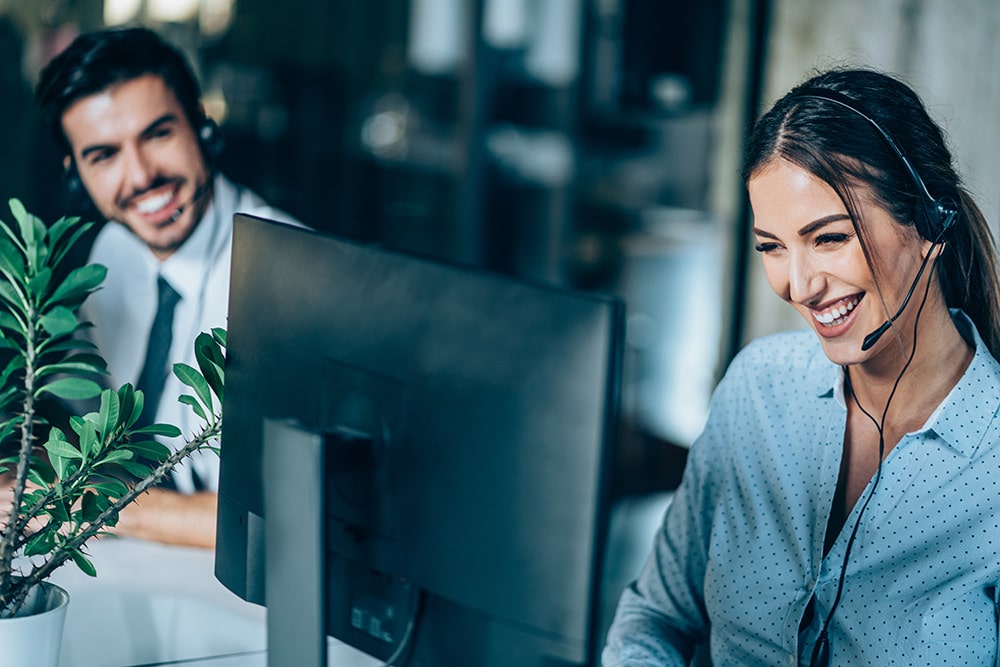 Female and male call center employees taking calls in office
